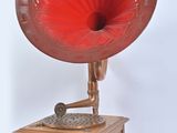 un gramophone rouge posé sur une table en bois