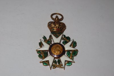 une médaille dorée et verte surmontée d'une couronne