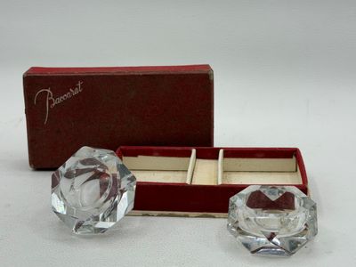 pair of clear glass candlesticks in a red box on a white surface