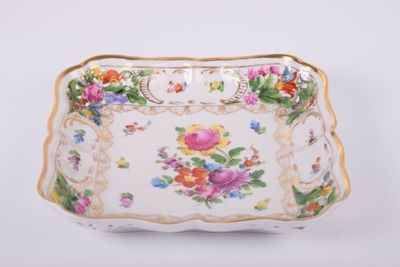 un plateau blanc orné de fleurs posé sur une table