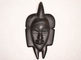 an image of a black mask hanging on a wall