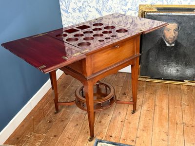 un tableau représentant un homme assis près d'une table sur laquelle se trouve un casier à bouteilles