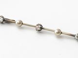 three pearl and diamond barbells on a white background