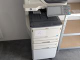 a printer sitting on top of a desk next to a shelf