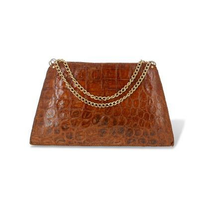 La pochette en cuir de crocodile marron est représentée sur un fond blanc