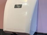 un distributeur de papier toilette fixé au mur de la salle de bains