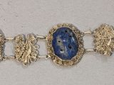 une photo en gros plan d'un bracelet orné de pierres bleues