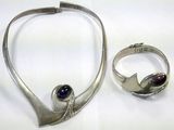 a silver necklace and ring with a purple stone on it