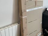 une pile de cartons posée par terre à côté d'un radiateur