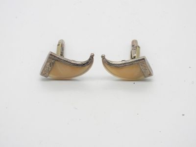 une paire de boucles d'oreilles en argent et en corne sur fond blanc