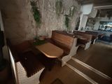 a table and benches in a room with a stone wall