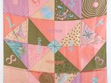 une couette en patchwork rose et verte accrochée au mur