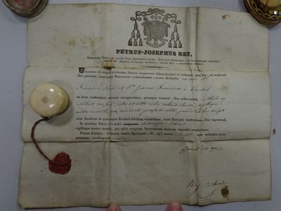 someone is holding a piece of paper with a wax seal on it