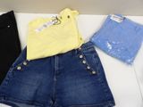 three pairs of shorts and a t - shirt sitting on a table