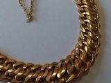 gros plan d'un collier à chaîne en or sur une surface blanche