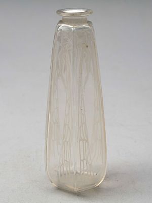 un vase en verre transparent muni d'un couvercle en argent, posé sur une table