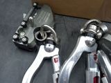 two pairs of clamps sitting next to a cardboard box