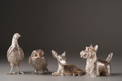 three silver figurines of animals and a bird sitting next to each other