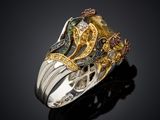 a close up of a gold and silver ring on a black surface