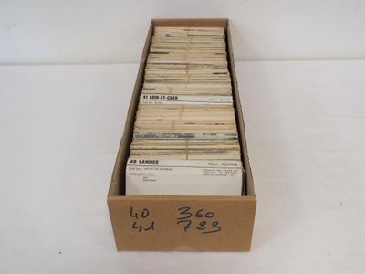 une boîte en carton ouverte, remplie de nombreux livres, posée sur une surface blanche