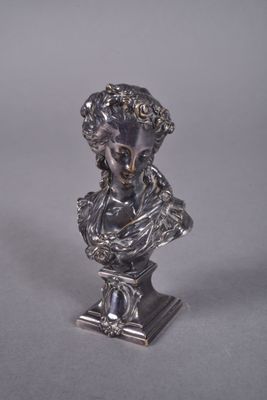 a close up of a silver statue of a woman on a pedestal