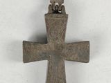 une vieille croix en métal sur laquelle est perché un oiseau