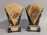 pair of black and white marble vases on stands on a gray background