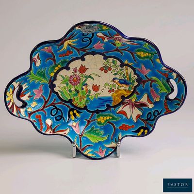 une assiette bleue ornée d'un motif représentant des fleurs et des oiseaux