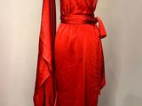 La robe rouge est exposée sur un présentoir à mannequin.