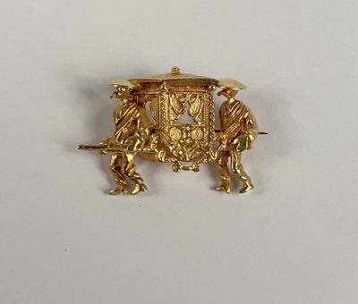une broche plaquée or représentant un cheval et une calèche