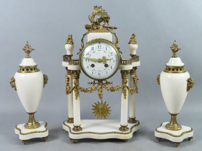 trois vases blancs et une horloge posés sur une table
