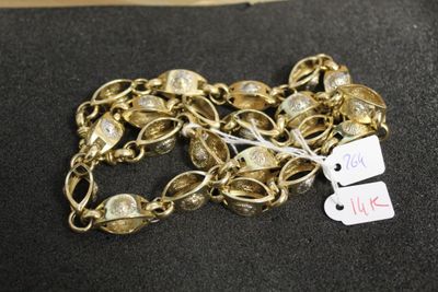 bracelet plaqué or avec des clochettes et une étiquette sur un fond noir