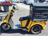 a yellow scooter with a box on the back of it