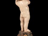 a small statue of a boy standing on a clock