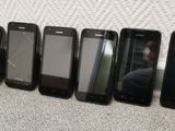 six cell phones are lined up in a row next to a wall