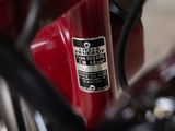 a close up of a red bike with a sticker on it