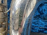 a close up of a silver saxophone with a blue background