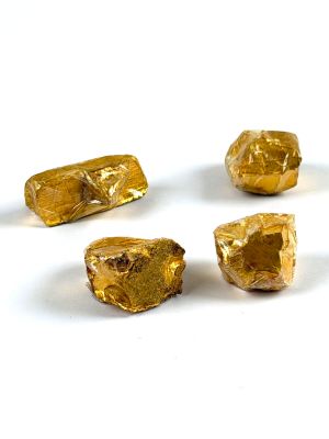 several pieces of gold are arranged in a circle on a white surface