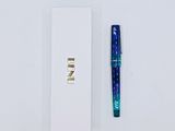 a pen that is laying next to a white box
