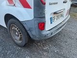une petite camionnette blanche à rayures rouges garée sur un parking