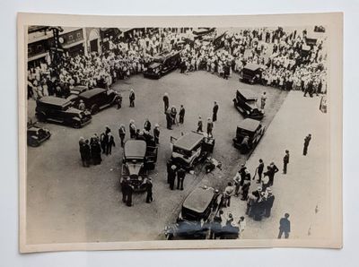 a black and white photo of a crowd of people watching a parade