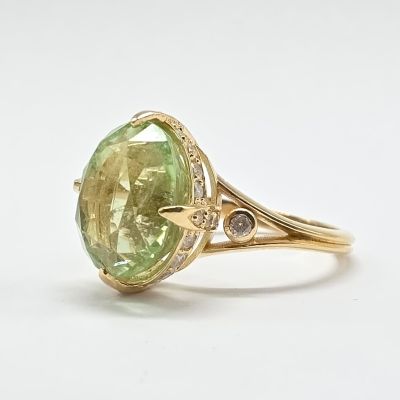 une image représentant une bague sertie d'une pierre verte et de diamants