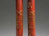 pair of red and gold painted columns with gold decorations