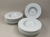 quatre assiettes blanches empilées les unes sur les autres sur une table