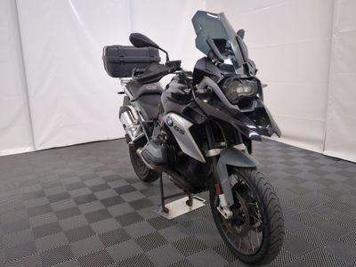 une photo d'une moto noire garée sur un sol à damier