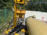 a large yellow pipe laying on the ground next to a fence