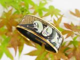 an image of a black and gold ring with two birds on it