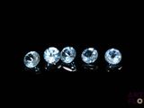 a group of five blue topaz diamonds sitting on top of a black surface