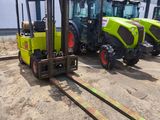 three yellow and green tractors parked next to each other in front of a building