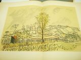 drawing of an open book with a picture of a village in the background